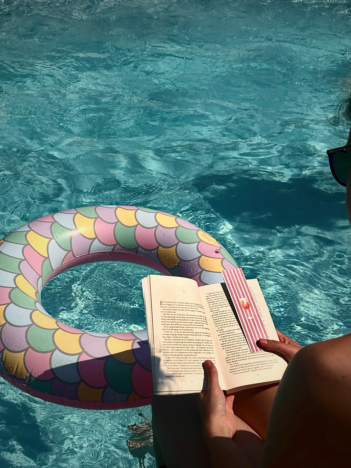 Een opengeslagen boek met ReadMark op een zwemband in het water
