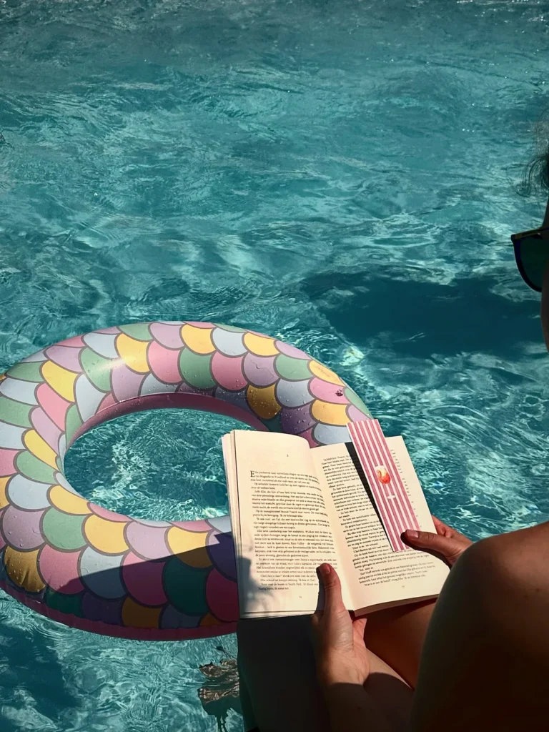 Een opengeslagen boek met een ReadMark op een zwemband in het water